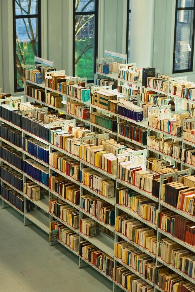 Mai multe cărți pe rafturile unei biblioteci