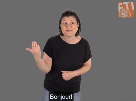 A woman saying 'bonjour' in sign language