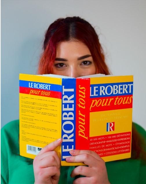 Picture of the author holding a French dictionary